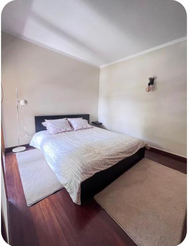 a bedroom with a large bed and a white wall at Casa SAL in Esposende