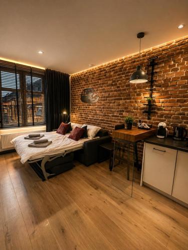 a bedroom with a bed and a brick wall at Brick Loft Nikiszowiec in Katowice
