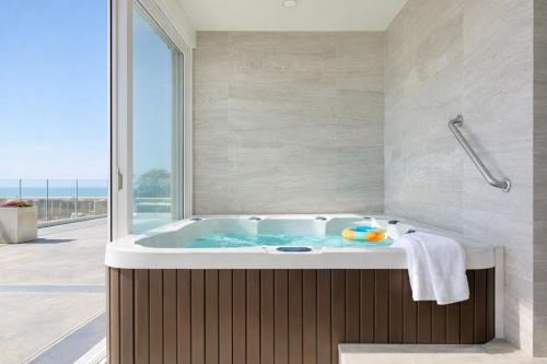 a bath tub in a bathroom with a large window at Panoramic Oceanfront Resort Style Condo in Rosarito