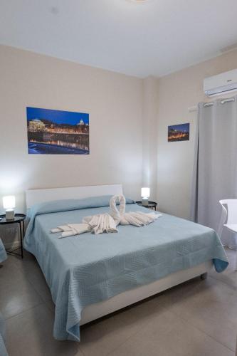 a bedroom with a bed with blue sheets and two tables at Umberto I in Nicosia