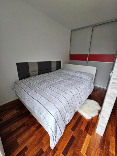 a bedroom with a bed and a wooden floor at Sončna vila Bovec, Studio A&B in Bovec