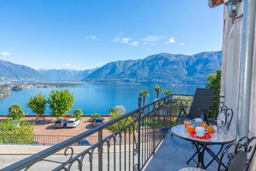 a balcony with a table and a view of a lake at Yellow View Apartment - Ronco S Ascona - Happy Rentals in Ronco sopra Ascona
