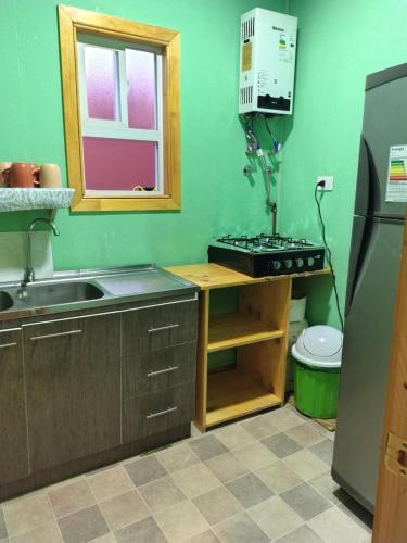 a kitchen with a sink and a stove at Casa kumey in Puerto Varas
