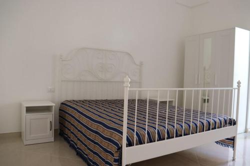 a bedroom with a white bed with a white bed frame at Villa Adriano in Salve