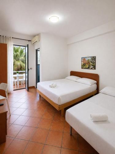 a hotel room with two beds and a balcony at Hotel Villa Megi in Golem