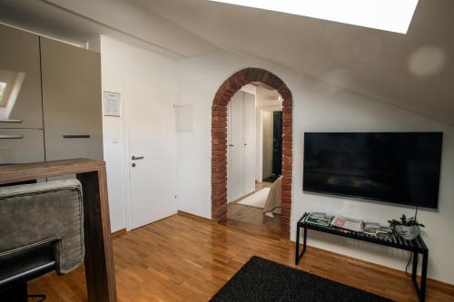 ein Wohnzimmer mit Fernseher und einer Backsteinwand in der Unterkunft UrbanStudio5 in Čakovec