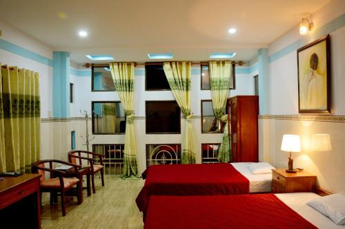 a hotel room with two beds and a table and chairs at Vien Duong Hotel in Quy Nhon