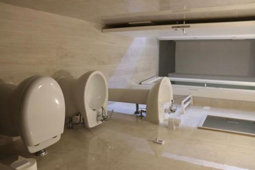 a bathroom with three urinals and a sink and a couch at Villa Adriano in Salve