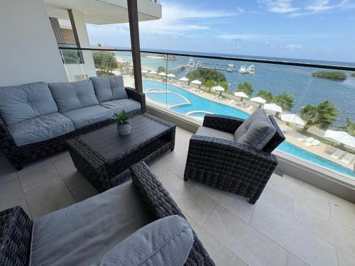 a living room with a couch and chairs and a pool at Playa Escondida in María Chiquita