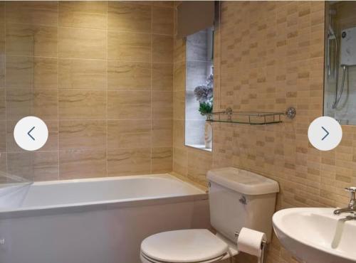a bathroom with a tub and a toilet and a sink at Annie Place in Whitby