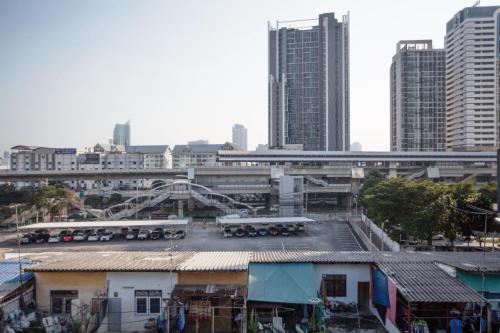 a parking lot in a city with tall buildings at Vera Nidhra - Self check-in after 6pm in Bangkok