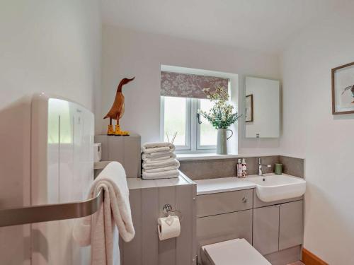 a bathroom with a sink and a bird statue on the counter at 1 Bed in Shepton Mallet oc-94296 in Pilton