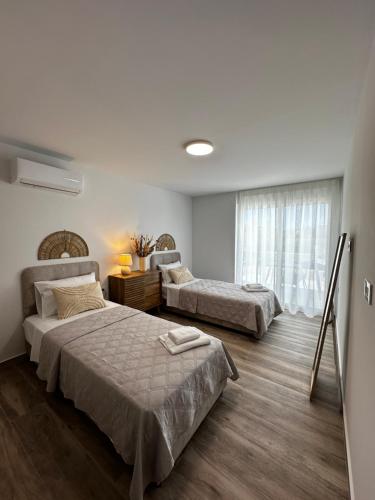 a bedroom with two beds and a window at Oleana Cosy Studio in Lampi
