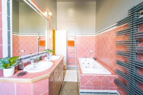 a bathroom with two sinks and a large mirror at Domaine La Cournonsécoise in Cournonsec