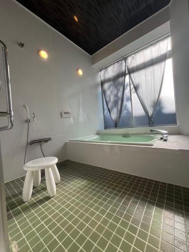 a bathroom with a tub and a table in it at コテージ銚子百里 in Hasaki
