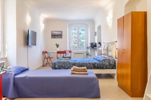 a bedroom with two beds and a table in a room at Ria Apartment in Le Grazie