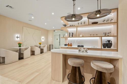 a kitchen with a counter and stools in a room at 17John Residences in New York