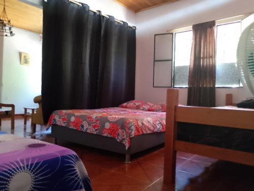 a bedroom with two beds and a window at Casa Sol y Alegría in Honda
