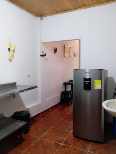 a stainless steel refrigerator in a room with a sink at Casa Sol y Alegría in Honda