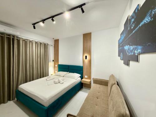 a bedroom with a bed and a couch at Full Moon Apartments in Ksamil
