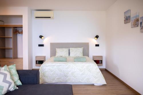 a bedroom with a bed and a couch at Cantinho FF in Santana