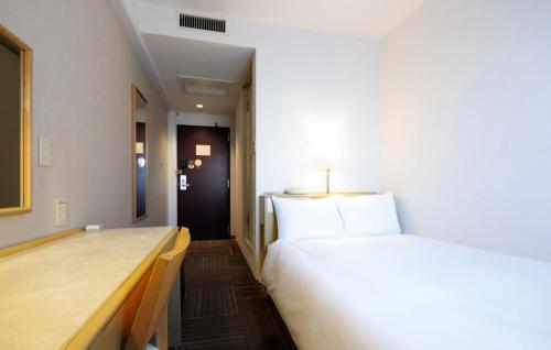 a hotel room with a bed and a desk at Court Hotel Mito in Mito