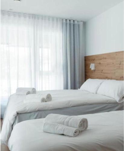two beds in a bedroom with towels on them at Donosti rooms in Loyola