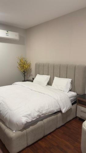 a bedroom with a large bed with white sheets at The Calm Suite in Al Khobar