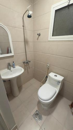 a bathroom with a toilet and a sink at The Calm Suite in Al Khobar