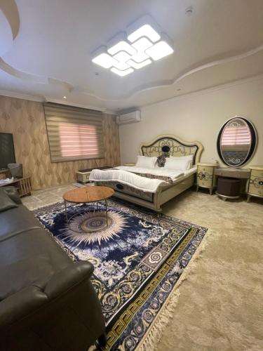 a bedroom with a bed and a table and a rug at دار ناصر in Riyadh
