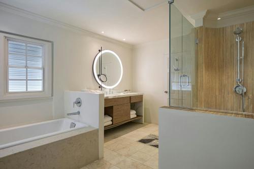 a bathroom with a tub and a sink and a mirror at Treasure Beach Art Hotel, An Autograph Collection All-Inclusive Resort in Saint James