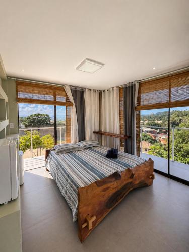 a bedroom with a large bed with a wooden log on it at Casa Luar da Sereia - Itacaré in Itacaré