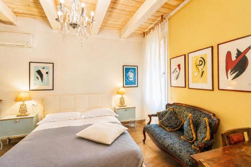 a bedroom with a bed and a chair at Al Battistero Luxury Suite in Ravenna