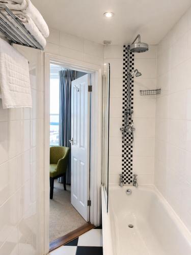 a white bathroom with a tub and a chair at The Royal Harbour Hotel in Ramsgate