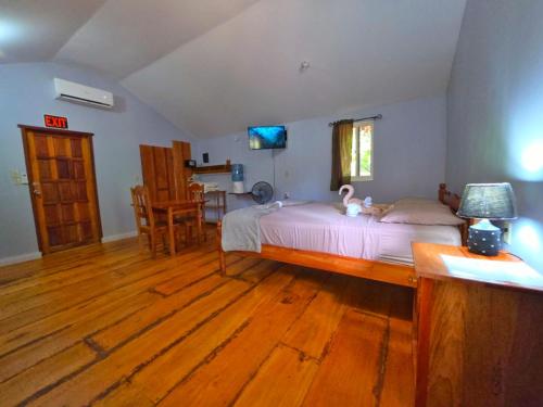 a bedroom with a bed and a wooden floor at Cotton Tree Cabin at Freshwater Creek Cabanas in Hopkins