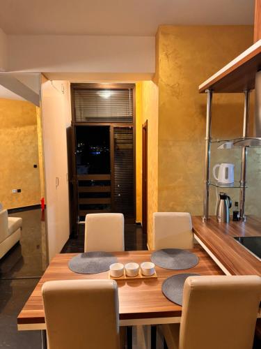 a dining room with a wooden table and chairs at Central Point Apartment in Bar
