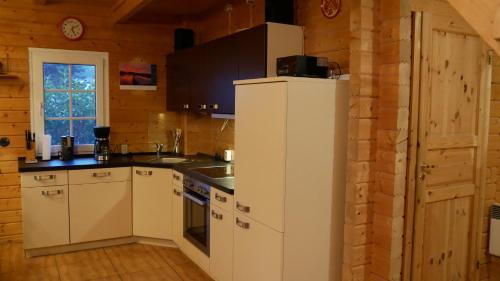 a kitchen with a white refrigerator in a room at Ferienhaus Milan mit Ruderboot - 300 m vom Fleesensee in Silz