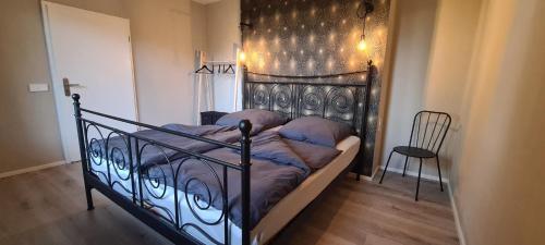 a black bed in a room with a chair at Etappenziel in Rengsdorf