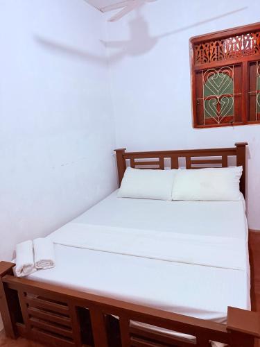 a bedroom with a bed with white sheets at Ela addara Home stay in Lukasgoda