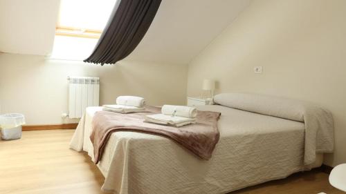 a bedroom with two beds with towels on it at Sleeping portomarin 1 in Portomarin