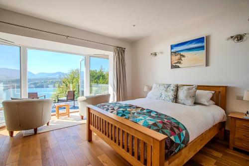 a bedroom with a bed and a large window at Seascape at coed y berclas, luxury accommodation with stunning sea view in Llandegfan