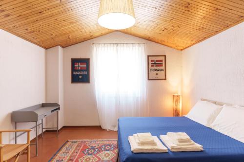 a bedroom with a blue bed and a window at Residenza Subasio Assisi in Rivotorto