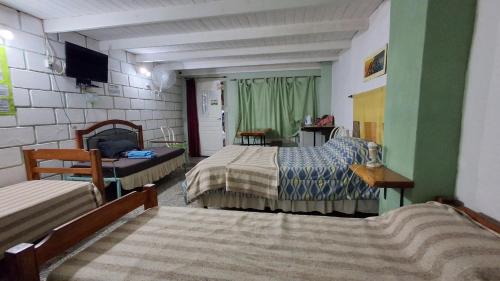 a hotel room with two beds and a television at BelDaMar in Capilla del Monte