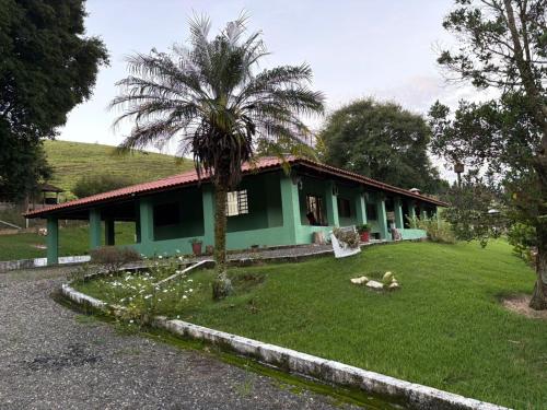 a green house with a palm tree in the yard at Chacara el Angel in Socorro