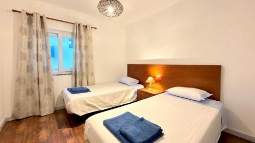 a bedroom with two beds and a window at Apartamento Sto Estevão in Zambujeira do Mar