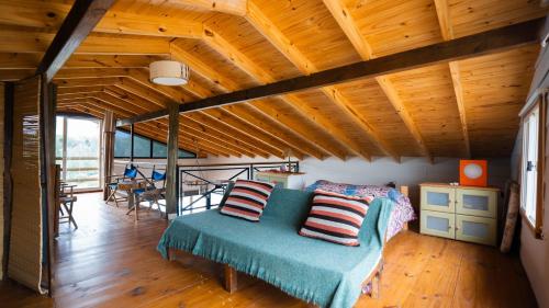 a bedroom with a bed in a room with wooden ceilings at Colores de Yacanto in Villa Yacanto