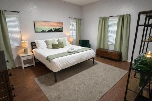 a bedroom with a white bed and two windows at Peaceful Inn at Deerfield Beach Boca Raton in Deerfield Beach