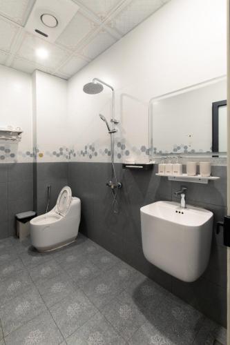 a bathroom with a sink and a shower and a toilet at Willow Stay in Hai Phong