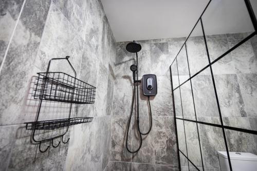 a bathroom with a shower and a phone on the wall at The Wheelhouse, Ballycastle in Ballycastle