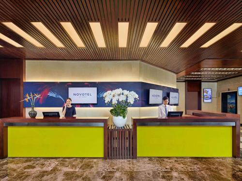 two people sitting at a desk in a lobby at Novotel Nha Trang in Nha Trang